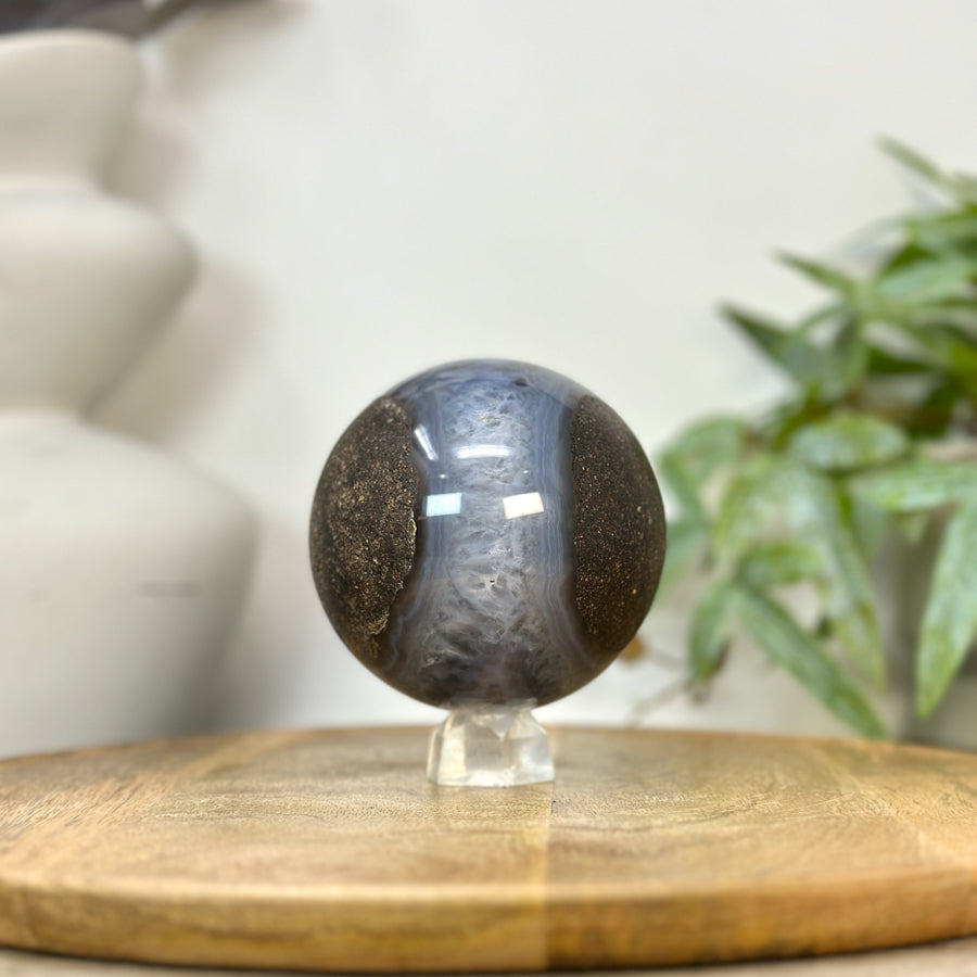 Blick von oben auf das obere Profil der Achat-Sphäre, der das plastische Volumen und das markante Zusammenspiel der Mineralschichten verdeutlicht.