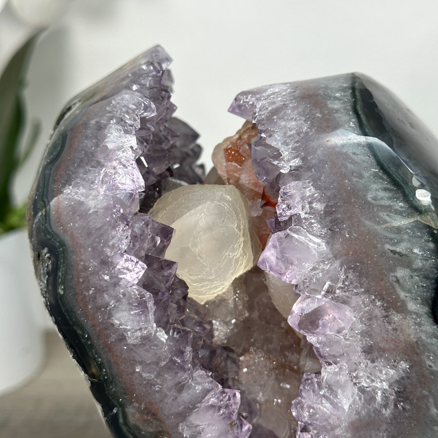 Amethyst-Geode mit eingebetteten Kalzit-Einschlüssen und vielschichtiger Kristallstruktur