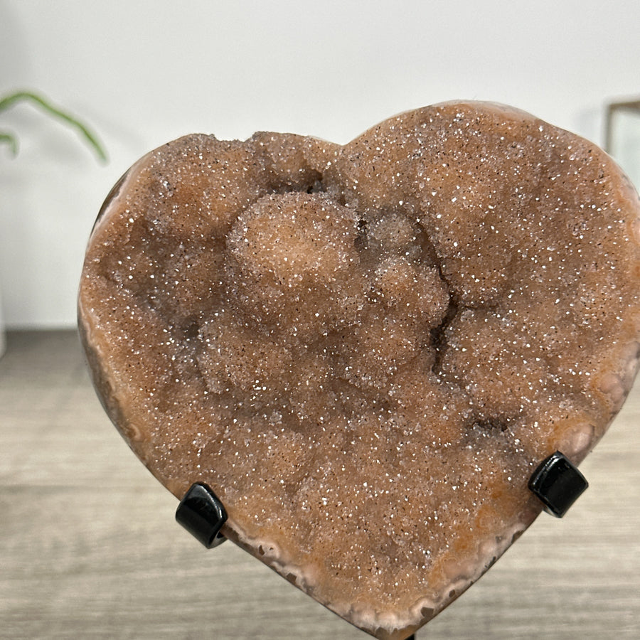 Quarz-Druzy-Herzskulptur mit orangefarbener, glitzernder Kristalloberfläche