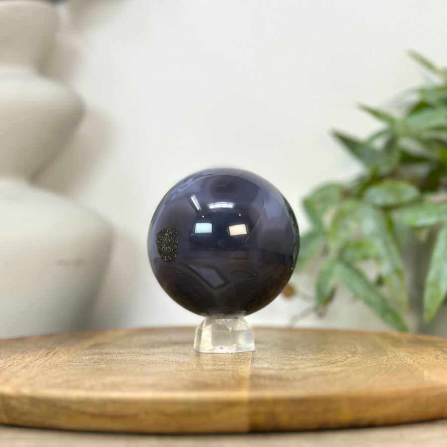Blick von oben auf das obere Profil der Achat-Sphäre, der das plastische Volumen und das markante Zusammenspiel der Mineralschichten verdeutlicht.
