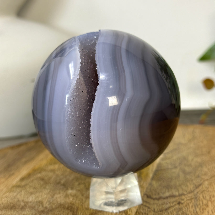 Schräge Seitenansicht der Naturstein-Kugel, die das perfekt runde Profil, die makellose Symmetrie und die plastische Tiefe des Innenraums zeigt.
