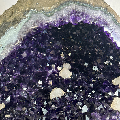 Perspektive von schräg hinten, die die organisch geschwungene, massive Form des echten 21,55 kg schweren Amethyst-Natursteins zeigt.