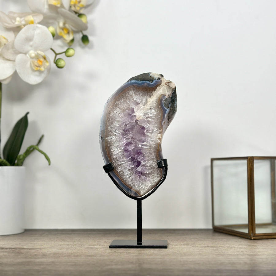 Echte Quarz- und Amethyst-Platte aus Uruguay mit klarer, hell-transparenter Kristallstruktur auf einem maßgefertigten, schwarzen Metallständer.