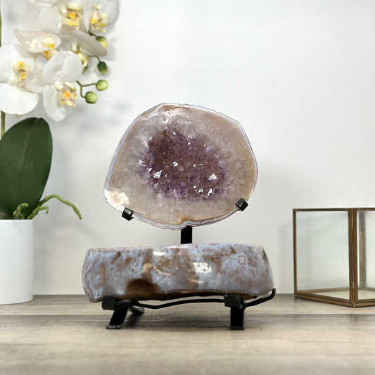 Echte Amethyst-Schatulle aus Uruguay mit geöffneter Kristallkammer und einer samtig tiefvioletten Kristallstruktur auf einem eleganten schwarzen Metallständer.