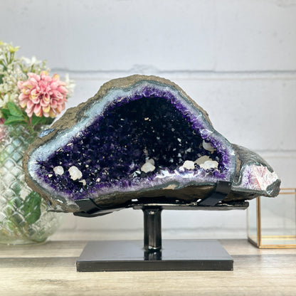 Massive Top-Grade Amethyst-Geode aus Uruguay mit weit geöffneter Kammer und tiefvioletten, intensiv funkelnden Kristallspitzen auf dunklem Untergrund.
