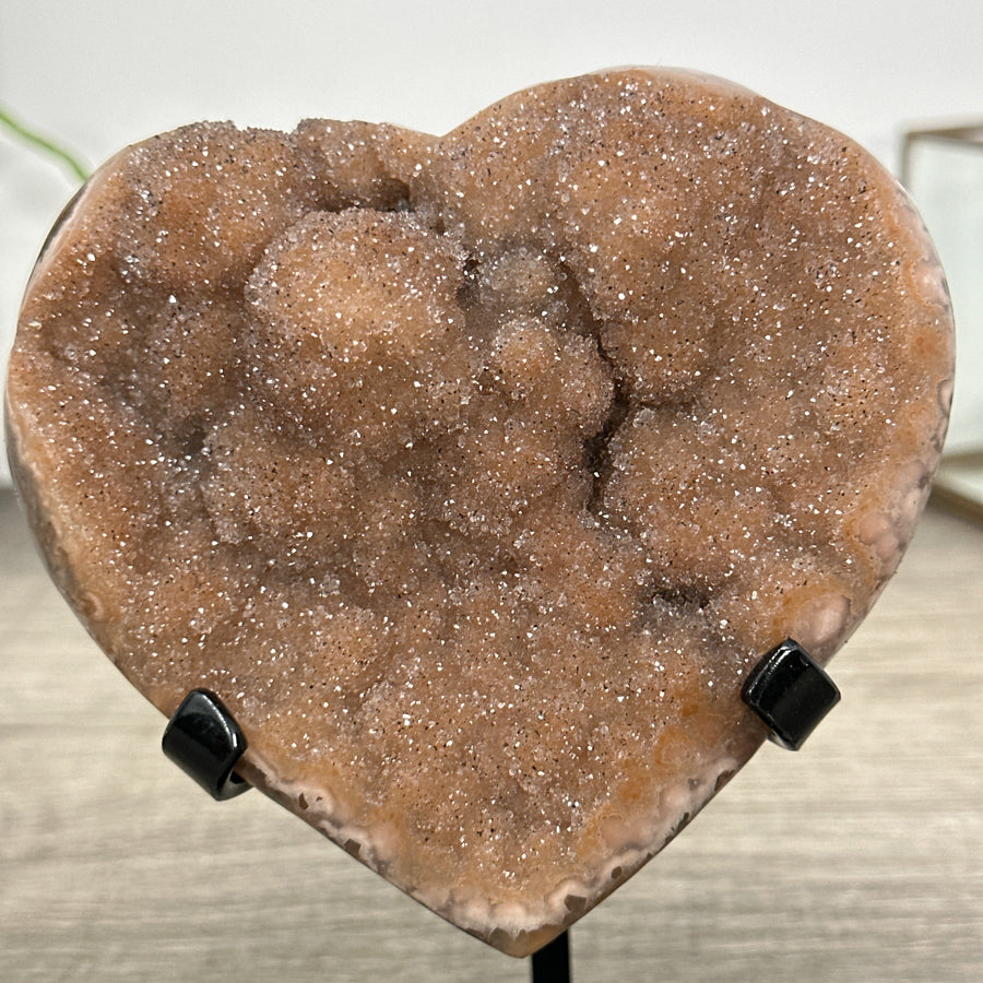Quarz-Druzy-Herzskulptur mit orangefarbener, glitzernder Kristalloberfläche