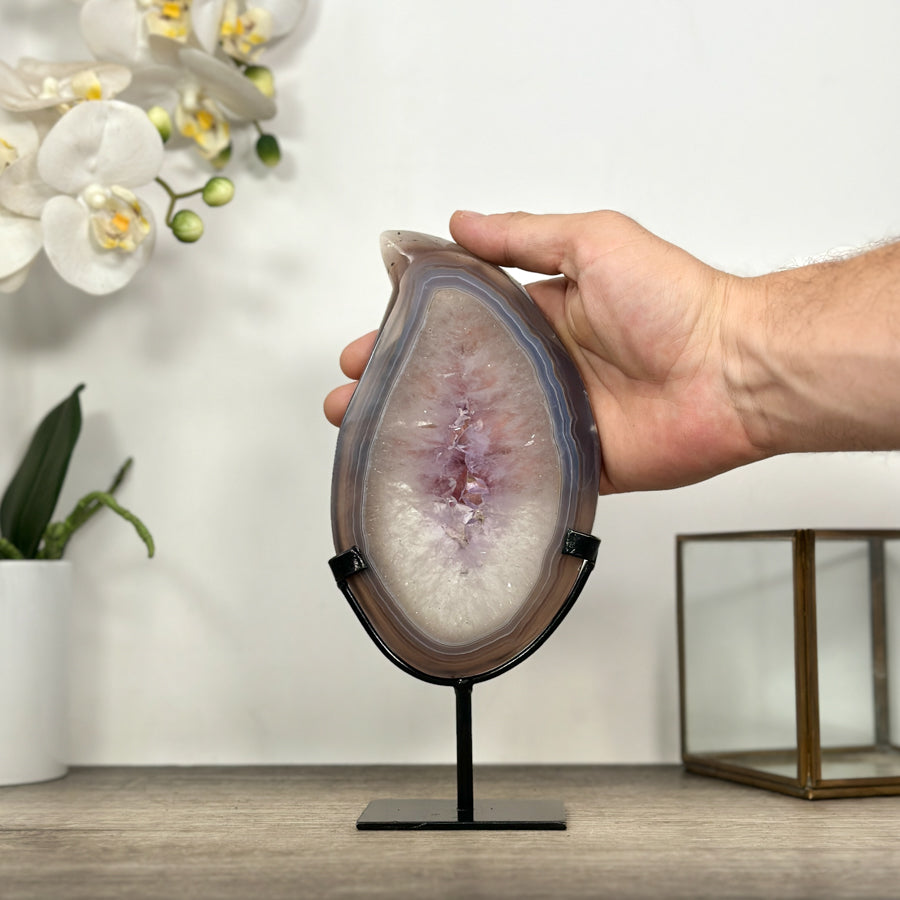 Eine Hand hält das Achat-Quarz-Portal, um die realen Proportionen und die Gesamthöhe von 22,5 cm zu demonstrieren.