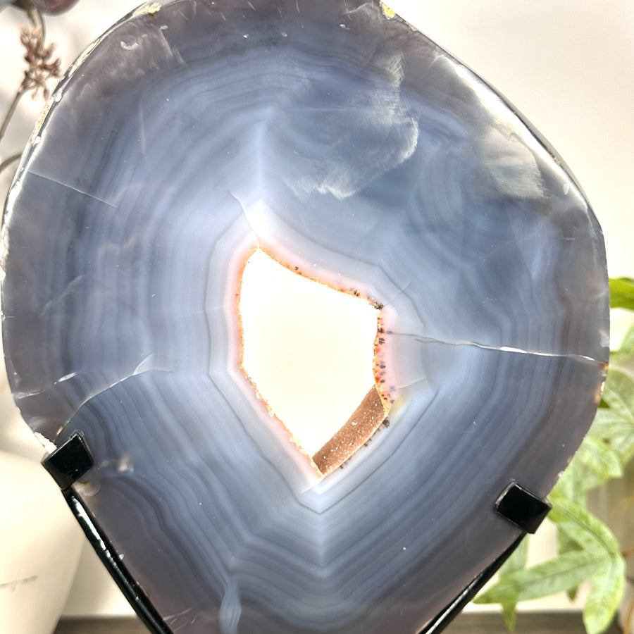 Rückseite des blauen Kristall-Portals, die die ursprüngliche, raue Gesteinsmatrix sowie die stabile, geschraubte Befestigung am schwarzen Metallständer abbildet.
