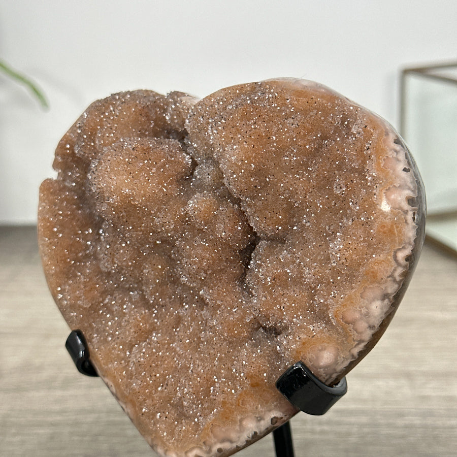 Quarz-Druzy-Herzskulptur mit orangefarbener, glitzernder Kristalloberfläche