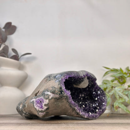 Rückansicht der geschlossenen Seite der Geode, die die raue, graue Gesteinsmatrix und die massive Beschaffenheit des 10,6 kg schweren Unikats zeigt.
