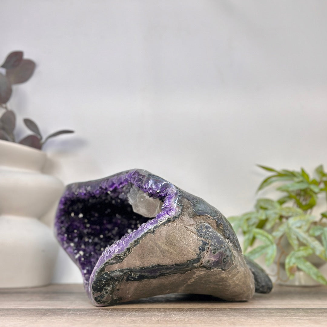 Perspektive von schräg hinten, die die organisch geschwungene, natürliche Form des echten Amethyst-Natursteins abbildet.