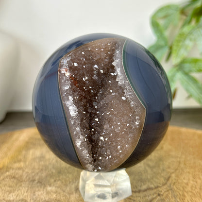 Makroaufnahme im Inneren der offenen Kugelhöhle mit Fokus auf die dichten, reliefartigen Strukturen der glitzernden Druzy-Kristallformation.
