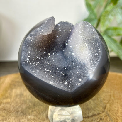 Perspektive von schräg hinten auf das 0,51 kg schwere Unikat, die den glänzenden Rundschliff und den organischen Verlauf der Mineralschichten betont.