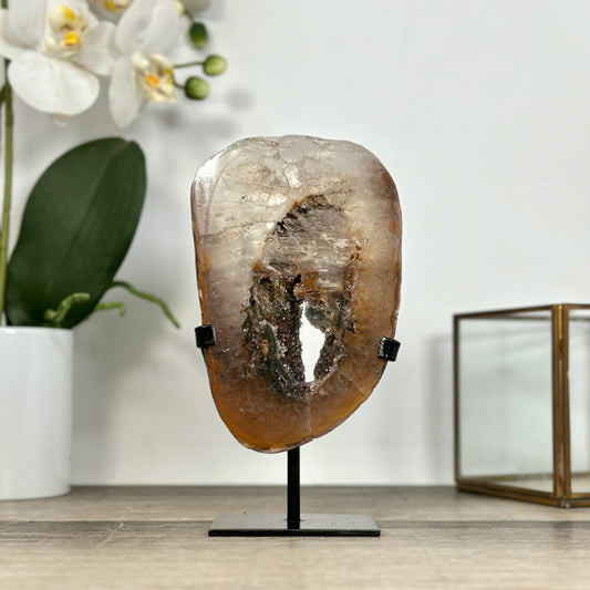 Echtes Quarz-Portal aus Uruguay mit seltenen, grün getönten Druzy-Kristallen und einer klaren Kristallstruktur auf einem minimalistischen, schwarzen Metallständer.